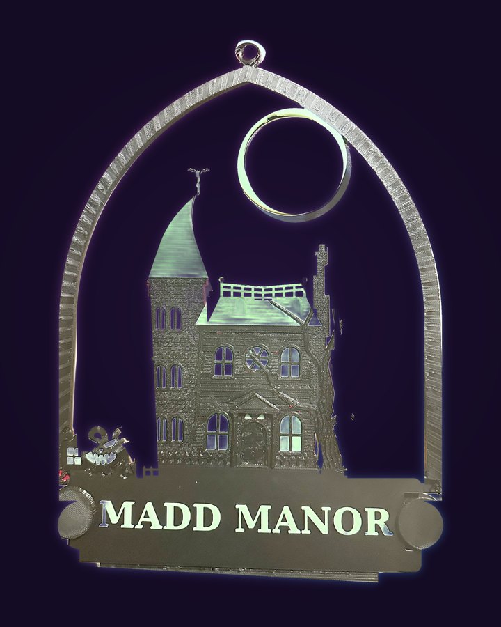 The printed Manor ornament, Halloween side: a black haunted house with a bat weathervane, a bare tree, a jack-o'-lantern by the gate, and a name plate at the bottom reading MADD MANOR