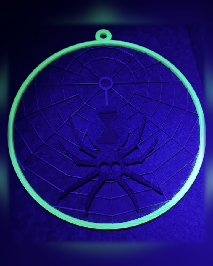 Widow's Glow under a blacklight: the ring glows bright green around a fine web and a black widow